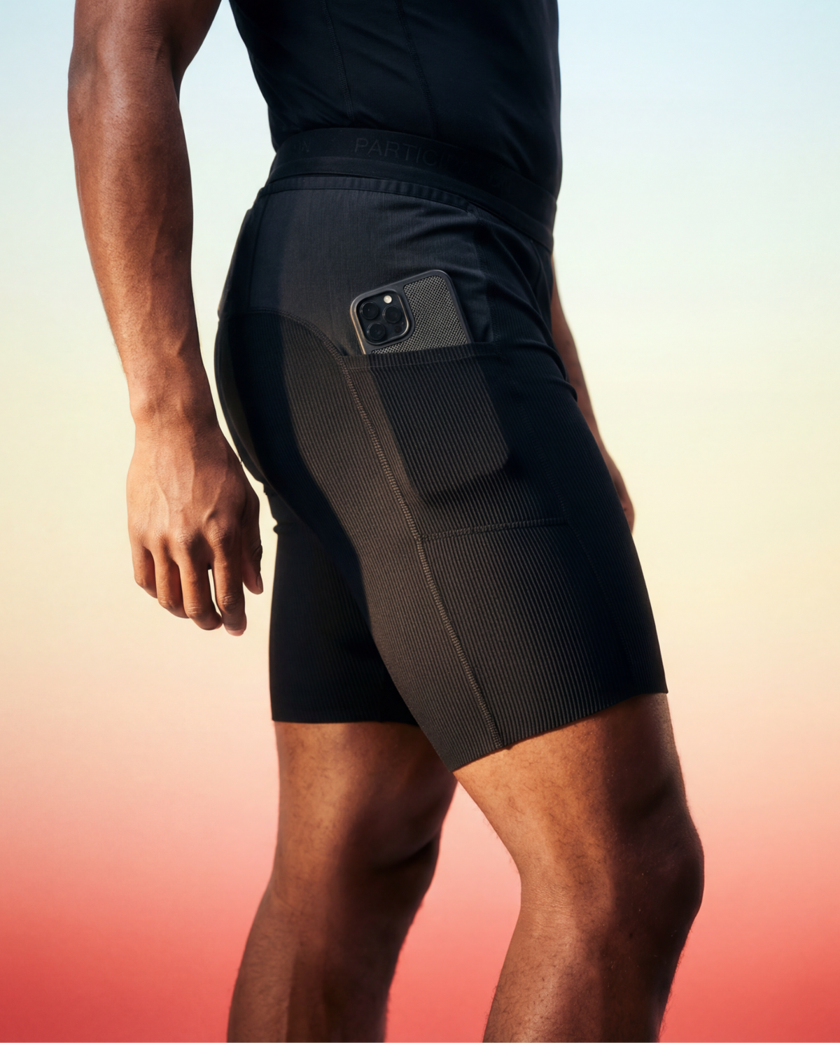 Runner wearing black Participation running tights, with a phone in the side pocket
